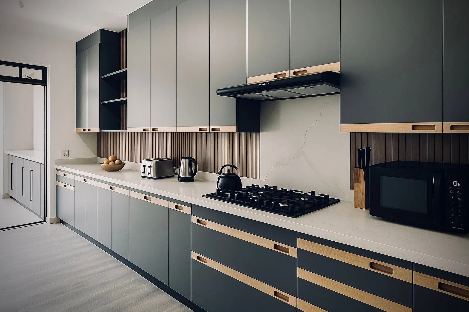 After — Hand-painted cabinetry in soft grey, paired with a wood-panel backsplash, stone countertops and warm under-cabinet lighting.